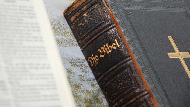 Eine geschlossene Bibel liegt auf einer aufgeschlagenen Bibel