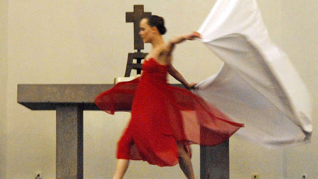 Tänzerin in rotem Kleid vor einem Altar