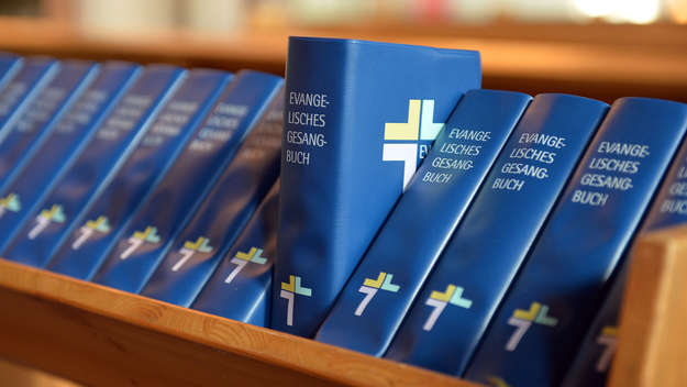 Aufgereihte Gesangbücher in einer Kirche