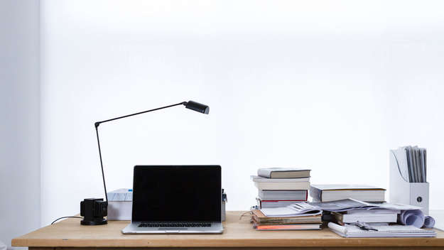 Schreibtisch mit Laptop, Büchern und Unterlagen