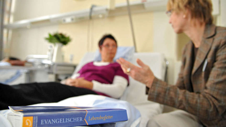 Eine Krankenhausseelsorgerin spricht mit einer Patientin im Diakoniekrankenhaus Friederikenstift Hannover.