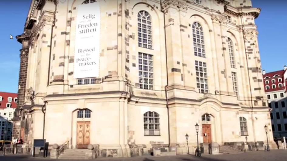 Die Frauenkirche in Dresden mit einem Banner mit dem Bibelvers „Selig sind die Frieden stiften“