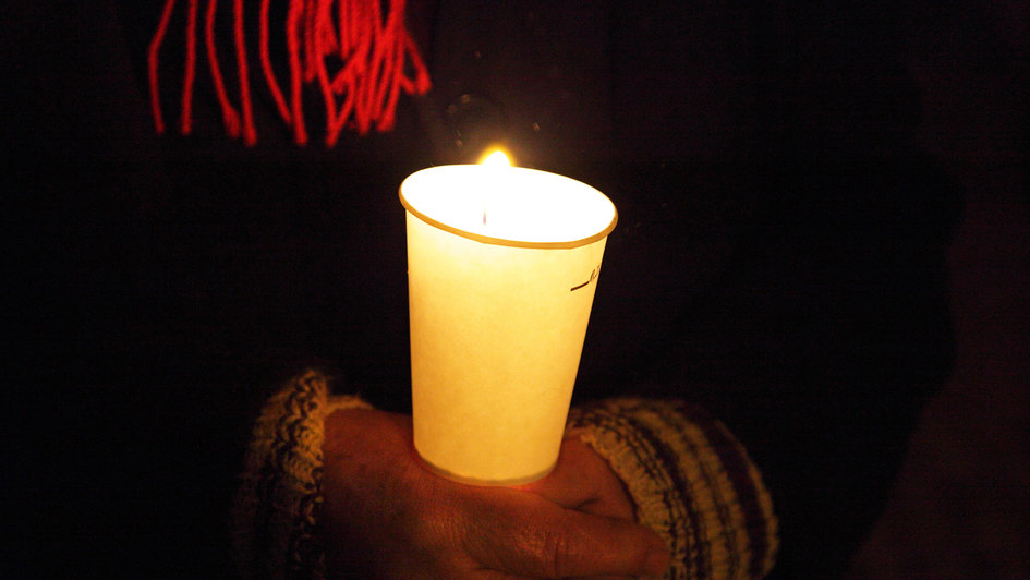 Kerze in den Händen während deiner Friedensandacht