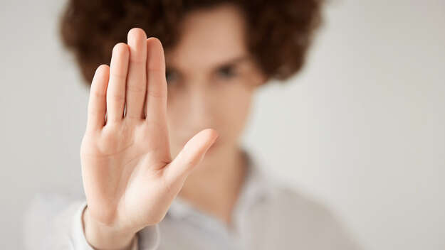 Eine Frau hebt die Hand als Stop-Zeichen. Eine Frau hebt die Hand als Stop-Zeichen.