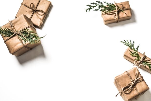 Weihnachtspäckchen in Packpapier, verziert mit Tannengrün