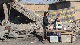 In der zerstörten Stadt Hajin in Syrien bieten Kinder am Wegesrand Waren zum Kauf an