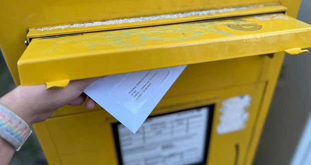 Brief wird in einen Briefkasten gesteckt