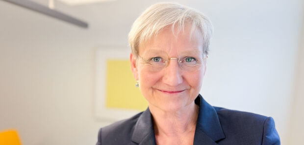 Kirsten Fehrs steht vor einem gelben Bild und hält die Osterbotschaft.