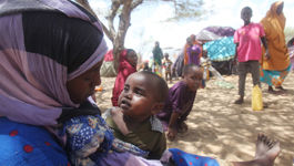 Lager für Vertriebene in Somalia Eine Mutter hält ihr Kind im Schoß und sitzt im Schutz des Al-rajal Lager am Rand von Mogadischu. Durch Regenmangel und andere Umwelteinflüsse ist in Somalia eine schweren Dürre und betrifft dort Millionen von Menschen.