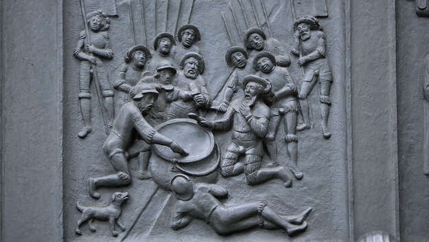 An der Westseite des Grossmünsters in Zuerich befindet sich das Zwingli-Portal. Hier in der Detailaufnahme auf der Tür die Kappeler Milchsuppe.