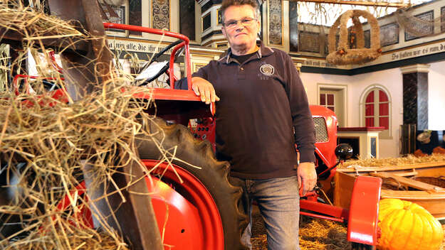Küster Günther Burwieck vor einem Traktor