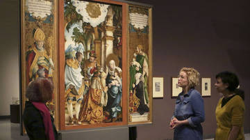 Ausstellungsbesucherinnen betrachten ein Altarbild des „Meisters von Meßkirch“