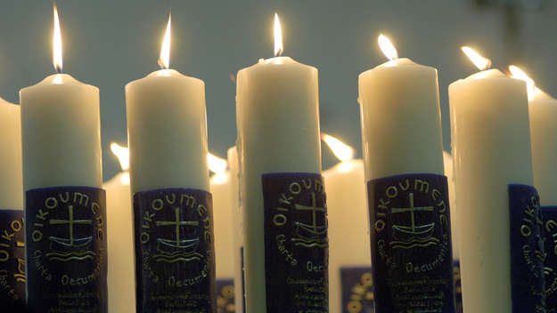 Brennende Kerzen mit dem Schriftzug „Ökumene“