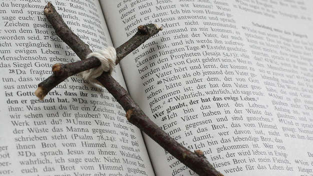 Ein Holzkreuz liegt auf einer Bibel