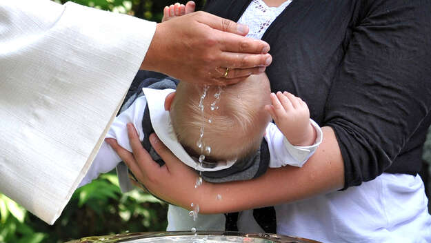 Pfarrer tauft Baby