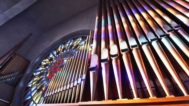 Orgelpfeifen im Licht farbiger Kirchenfenster