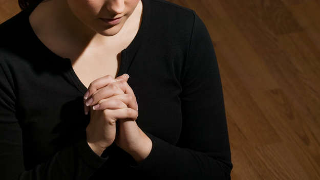 Eine Frau betet mit gefalteten Händen.