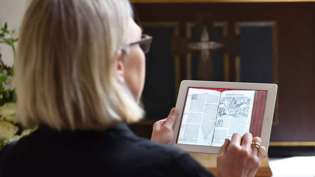 Eine Pfarrerin liest die Bibel auf ihrem iPad in einer evangelischen Kirche in Hannover.