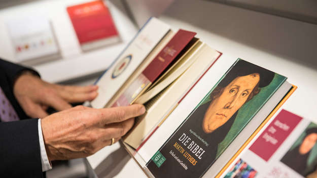 Verschiedene Ausgaben der neuen Bibel und Bücher in einem Regal am Stand der Deutschen Bibelgesellschaft bei der Buchmesse 2016.
