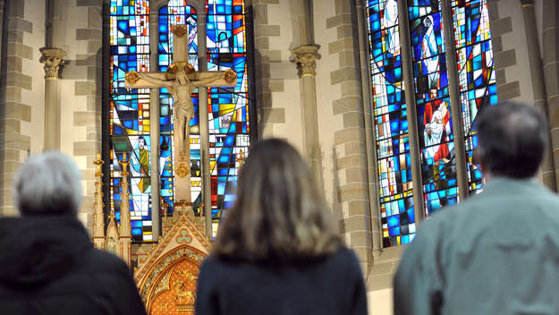 Drei Gottesdienstbesucher stehen vor dem Altar in der evangelisch-lutherischen Gartenkirche St. Marien in Hannover.