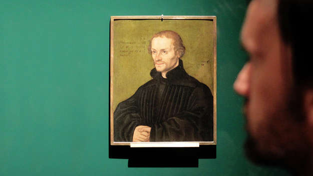 Ein Besucher betrachtet ein Porträt Philipp Melanchthons, gemalt von Lucas Cranach d.Ae, in der Ausstellung 'Luther und die Fürsten' auf Schloss Hartenfels in Torgau.