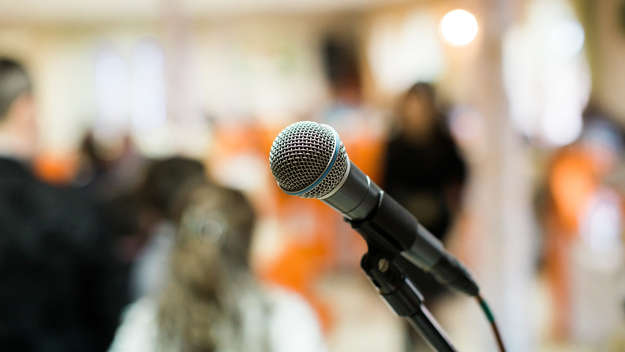 Ein Mikrofon steht in einem Raum für einen Redner bereit.