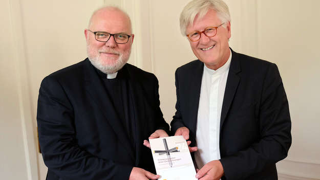 Der Vorsitzende der katholischen Deutschen Bischofskonferenz, Kardinal Reinhard Marx (li.), und der Ratsvorsitzende der Evangelischen Kirche in Deutschland (EKD), Landesbischof Heinrich Bedford-Strohm (li.), stellen in München ein Gemeinsames Wort zum Ref