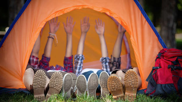 Drei Jugendliche liegen in einem Zelt.