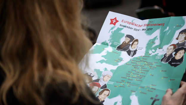 Eine Frau sieht sich eine Europakarte mit den eingezeichneten Stationen des Geschichtenmobils an.