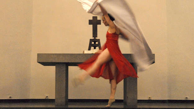 Eine Frau tanzt vor dem Altar in der Karthäuserkirche in Köln.