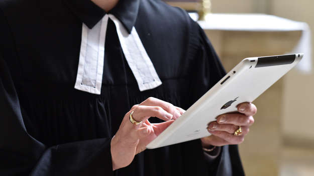 Nahaufnahme einer Pfarrerin mit einem Tablet-Computer in der Hand.