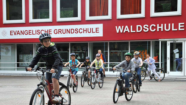 Schüler auf Fahrrädern vor der  Evangelischen Waldschule Eichelkamp in Wolfsburg.