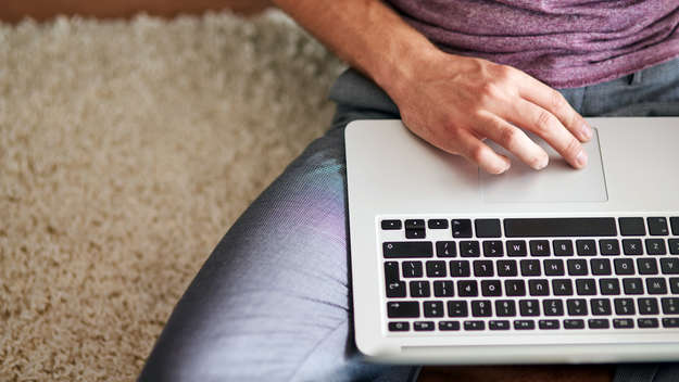 Mann mit Laptop auf dem Schoß.