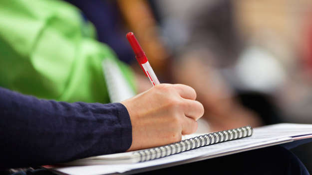 Nahaufnahme Hand mit Stift auf Notizblock.