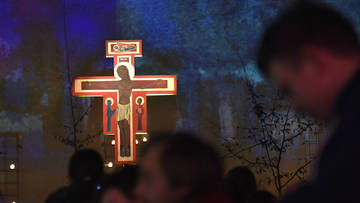 Betende vor dem erleuchteten Taizé-Kreuz