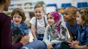 Leherin mit multikultureller Gruppe von Kindern