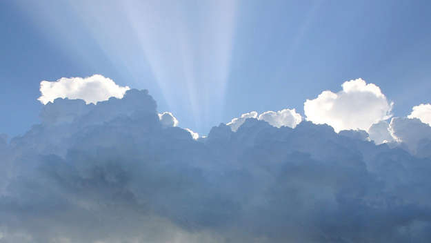 Der Himmel bricht auf: Sonnenstrahlen hinter einer Wolke