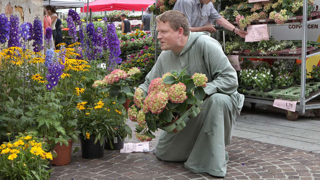 Bruder Markus von der Ev. Bruderschaft Kecharismai in Dettingen richtet auf dem Wochenmarkt den Blumenstand der Bruderschaft ein.