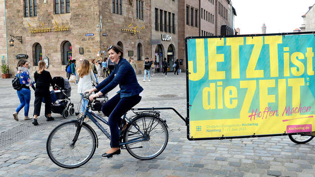 Kristion Jahn mit dem Motivplakat des Kirchentags