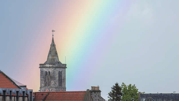 Regenbogen über einem Kirchturm