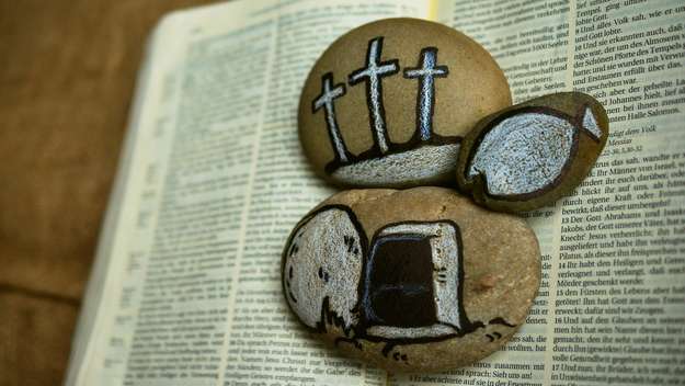 Offene Bibel mit drei Steinen drauf