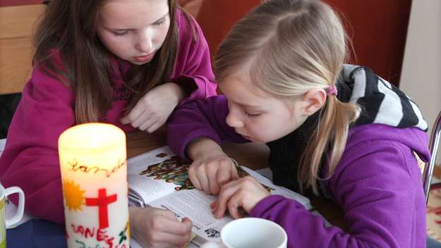 Zwei Mädchen lesen in einer Kinderbibel