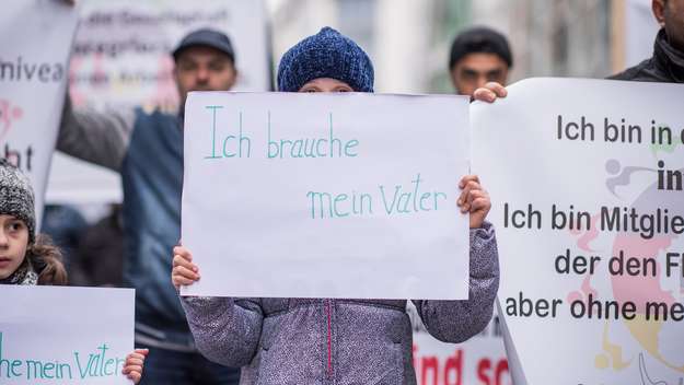 Kind mit einem Banner, auf dem steht: „Ich brauche mein Vater“