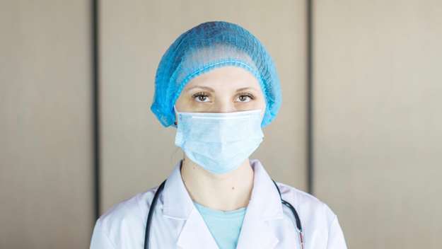 Krankenschwester mit medizinischer Mund-Nasen-Bedeckung