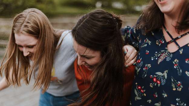 Drei junge Frauen lachen zusammen