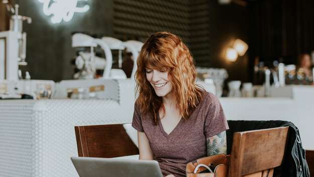 Frau sitzt in einem Café am Laptop