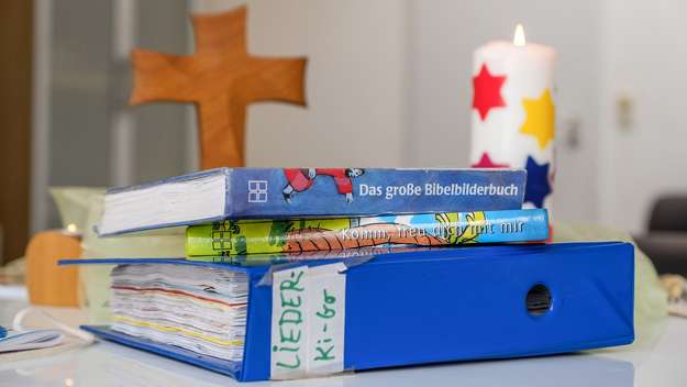 Liederordner, Bücher, Kreuz und Kerze für den Kindergottesdienst