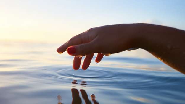 Hand berührt Wasser