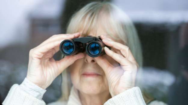 Symbolbild: Eine ältere Frau schaut durch ein Fernglas