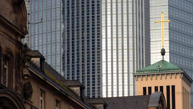 Turmkreuz der evangelischen Matthäuskirche vor Banken- und Bürogebäuden in Frankfurt am Main